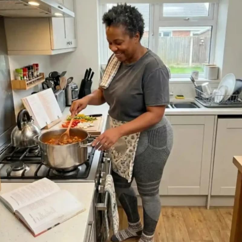 Woman cooking in her kitchen wearing grey YLA 3D leggings